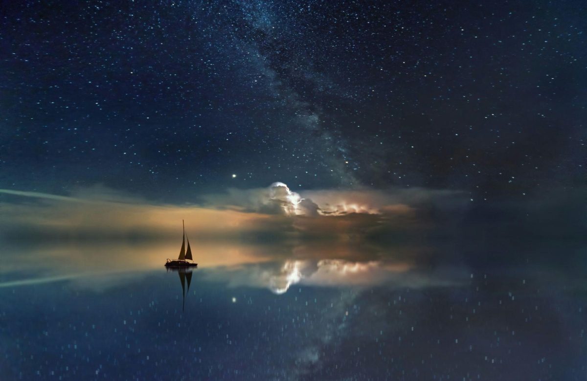A sailboat glides on water beneath a starry sky, symbolizing the role of dreams in spiritual growth.