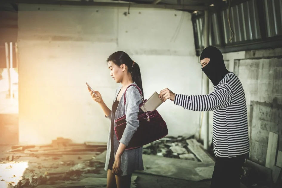Thief stealing wallet from distracted woman in dim setting, symbolizing loss, danger, and vulnerability