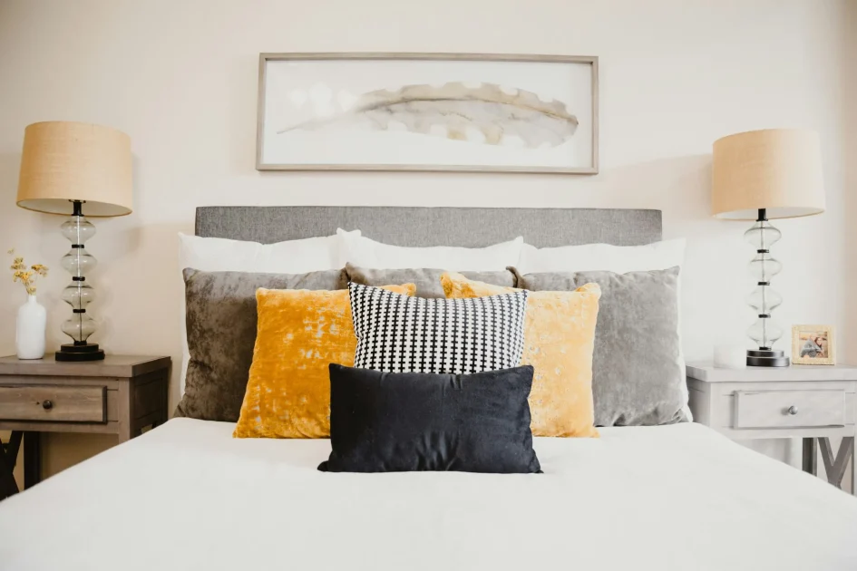 Neatly arranged bed with decorative pillows and bedside lamps, representing comfort, rest, and peaceful sleep