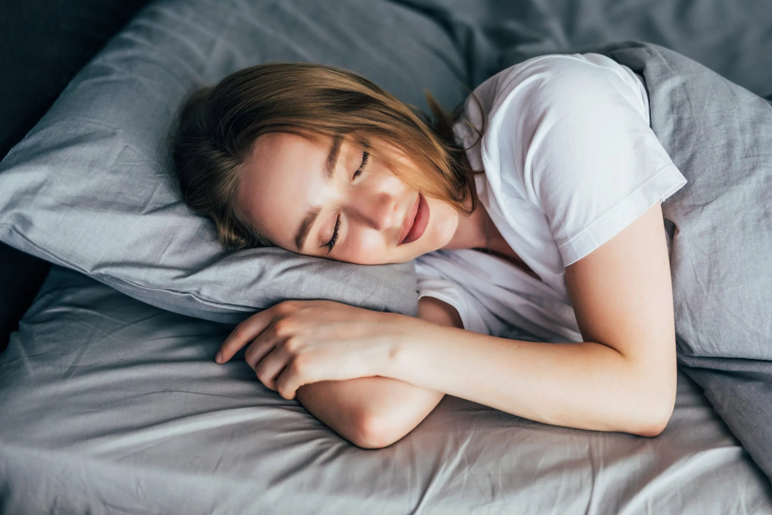 Woman sleeping peacefully on a pillow, representing deep rest, relaxation, and healthy sleep