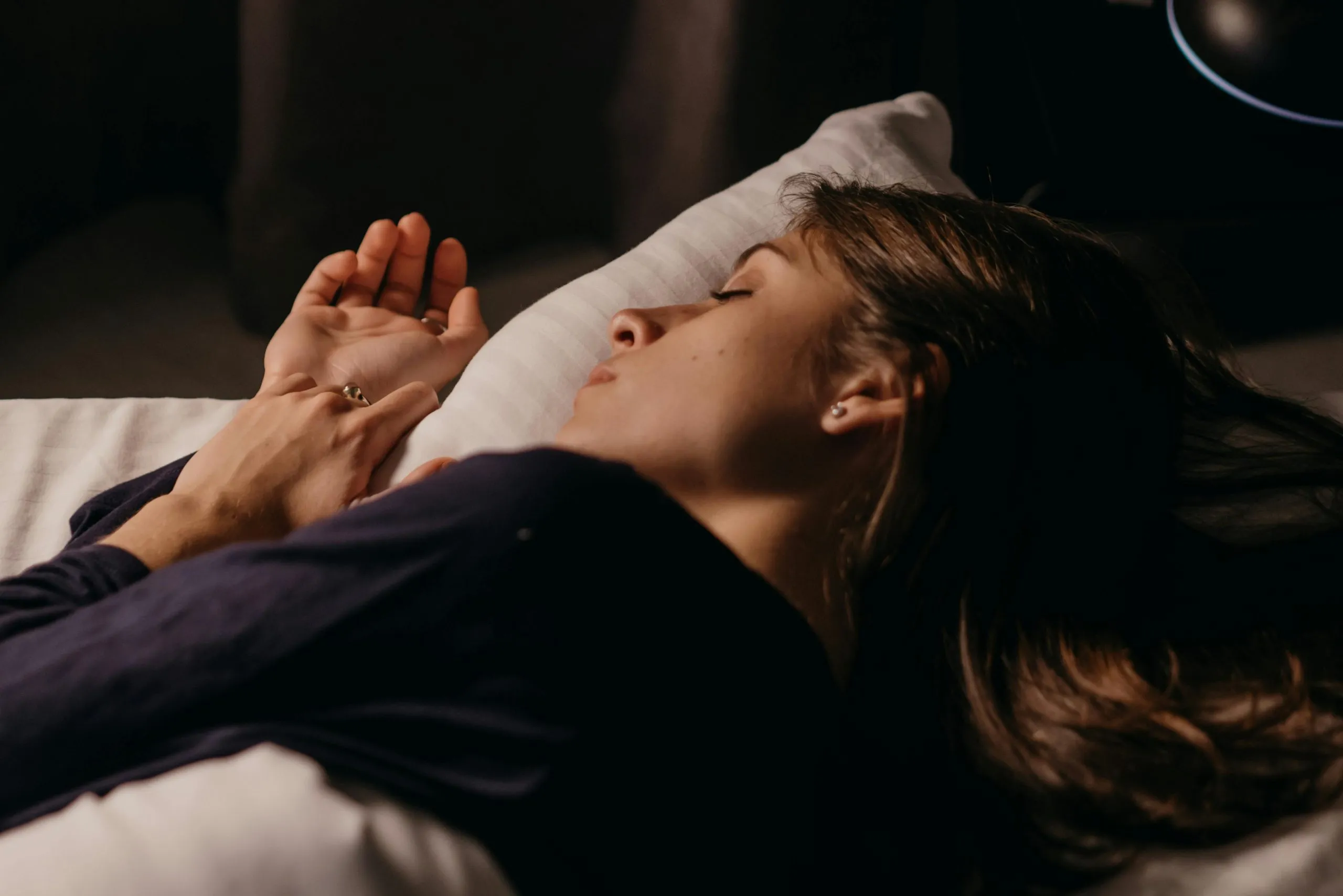 Woman sleeping quietly in a dim room, representing deep rest, dreams, and nighttime relaxation